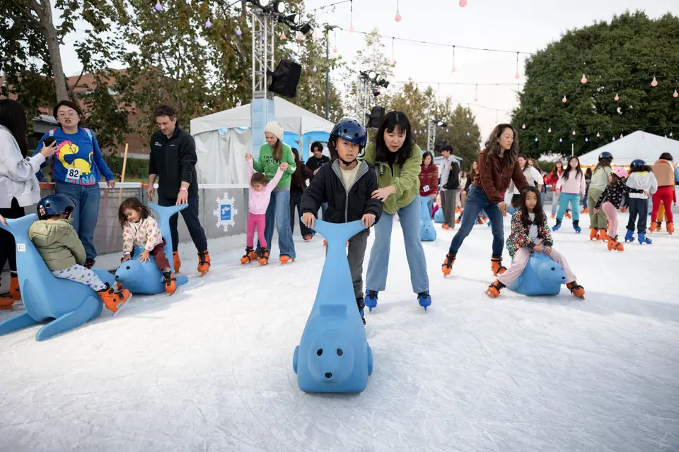 Young skaters with seal-shaped skating aids during a lesson