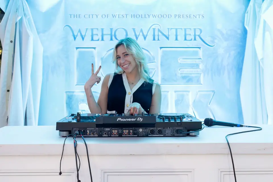 The DJ at the booth in front of the rink logo