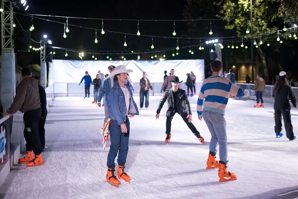 Skaters under string lights during a night session